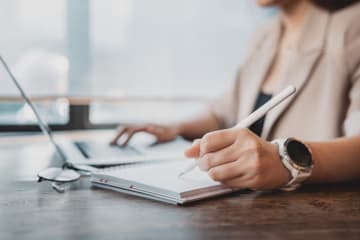 Woman writing a conference paper on her laptop