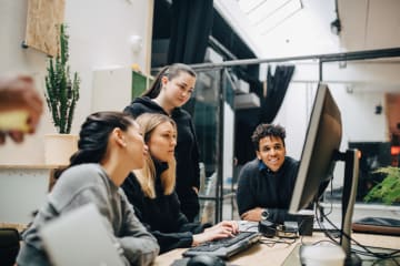 Colleagues discussing over computer