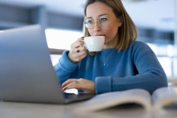 Student focusing on homework while drinking tea