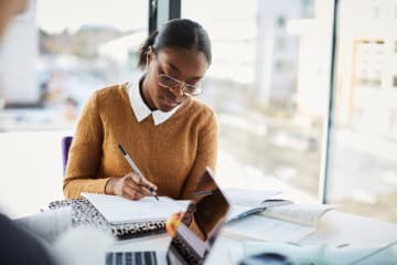 Adult student studying her notes at a table