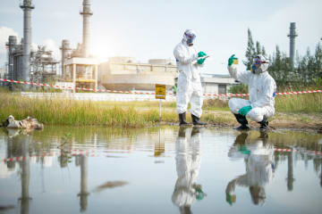 Ecologists examine water near a chemical plant