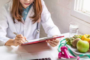 Female public health nutritionist reviewing a client's chart