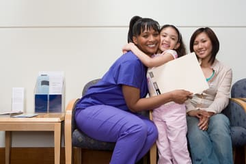 Little girl happily hugging family nurse practitioner after appointment