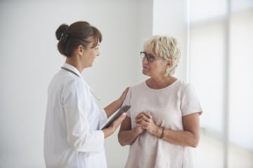 Female health communications specialist talking with female patient in office