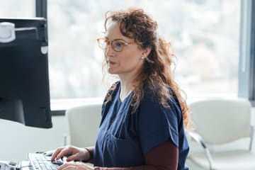 Healthcare professional with MPH degree looking at computer screen
