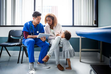 Nurse explaining test results to mother with toddler