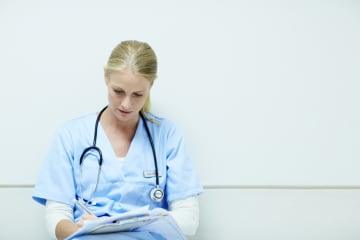 Nurse sitting and filling out paperwork