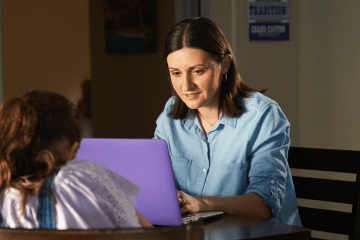 Woman teacher speaks with girl student in office setting