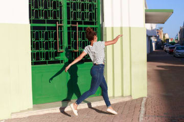 Woman joyfully skips along the sidewalk