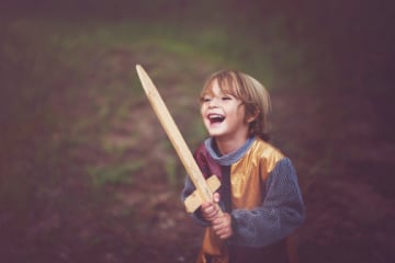 Happy boy with peace in knight costume