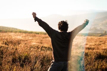 Man celebrating with his hands lifted