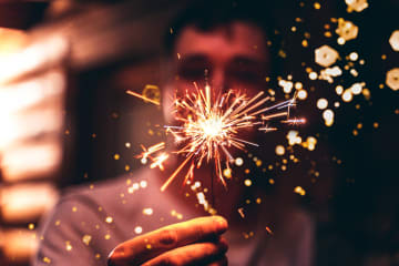 Man holding sparkler on New Year's Eve