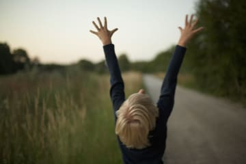 Young man throws his hands towards the Heavens