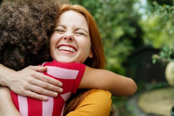 Women hugging each other showing greatest commandment