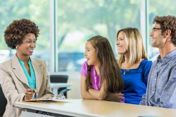 female teacher in school with student and family