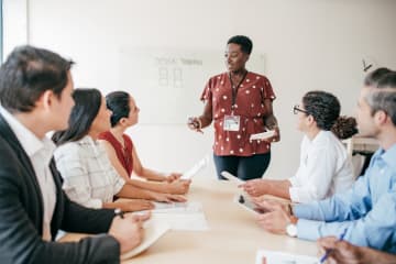 Female educational consultant talking with group of teachers