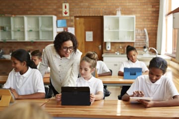 female teacher teaching young students in classroom learning environment