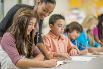 middle school teacher working with group of students