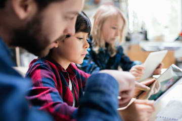 Teacher helping student with ipad and accessing their class information