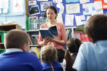 female teacher reading in front of class