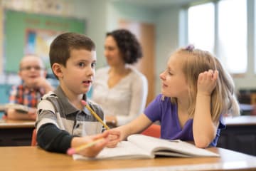 Two young students working together in class