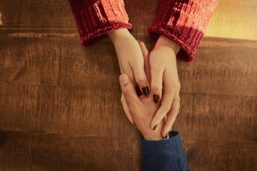 Woman hands enclasps a male hand