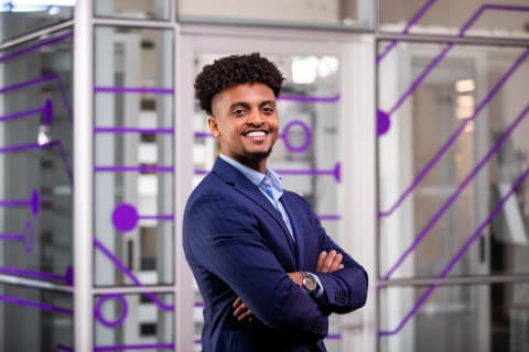 Male BS in Cybersecurity student smiling in conference room