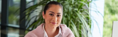 Psychiatrist sitting at office on computer with plants behind her