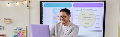 Male master's in education degree student gives gives presentation in front of classroom