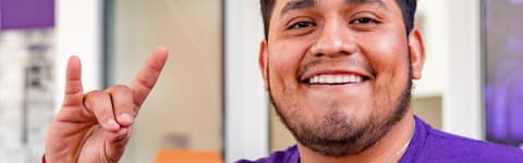 Jonathan Rosas smiling while showing "lopes up" hand sign