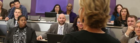 doctoral students listening to their professor