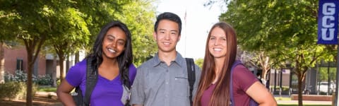 three students on campus working towards their bachelors