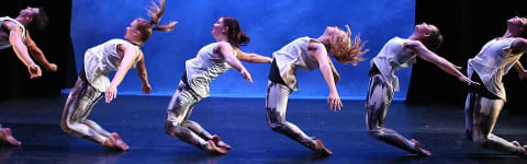 group of six dancers in a gravity defying position in unison 