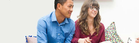 A couple sitting on the couch talking with counselor