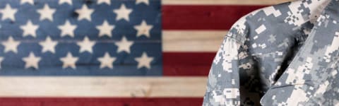 A soldier in uniform with an American flag behind them