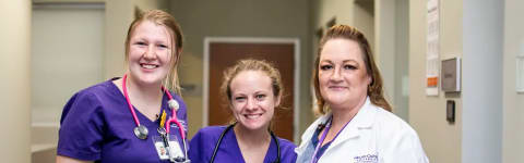 Two female nursing students and female GCU nursing instructor smile in hospital