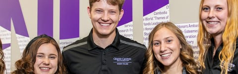 Students standing in front of Honors sign on the wall