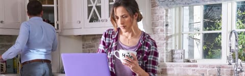 mother taking a class with her laptop in the kitchen