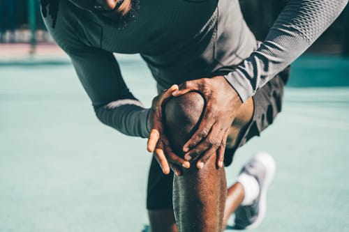 Man checking his knee for pain