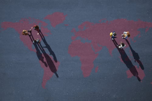 Two small groups of people, having discussion. Standing on world map, painted on asphalt - stock photo