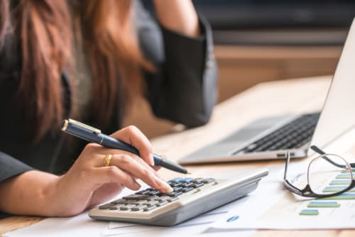 woman's using a calculator and working on laptop