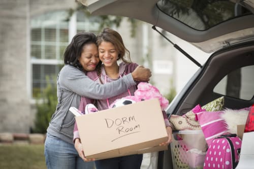 Mother hugging daughter goodbye as she moves into a dorm