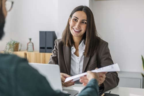 interviewee handing interviewer paper resume