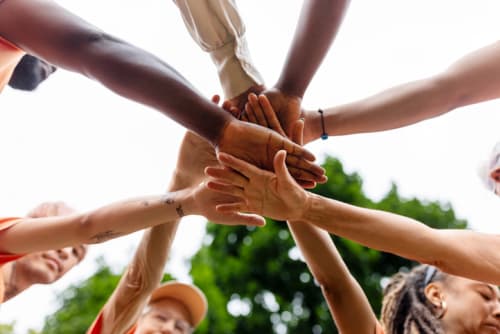 eight people joining hands together as a team