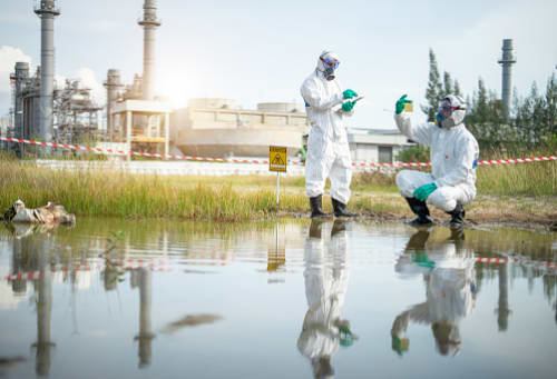 Ecologists examine water near a chemical plant