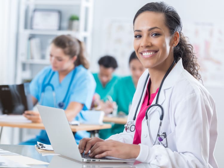 A woman in a lab coat smiling