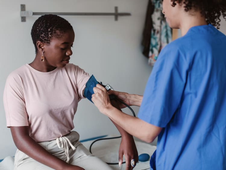 a nurse taking the blood pressure of a patient