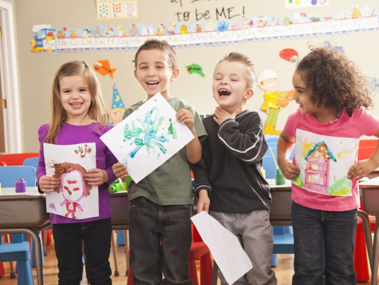 preschool children displaying their artwork