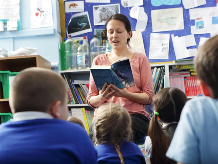 a teacher reading to elementary students