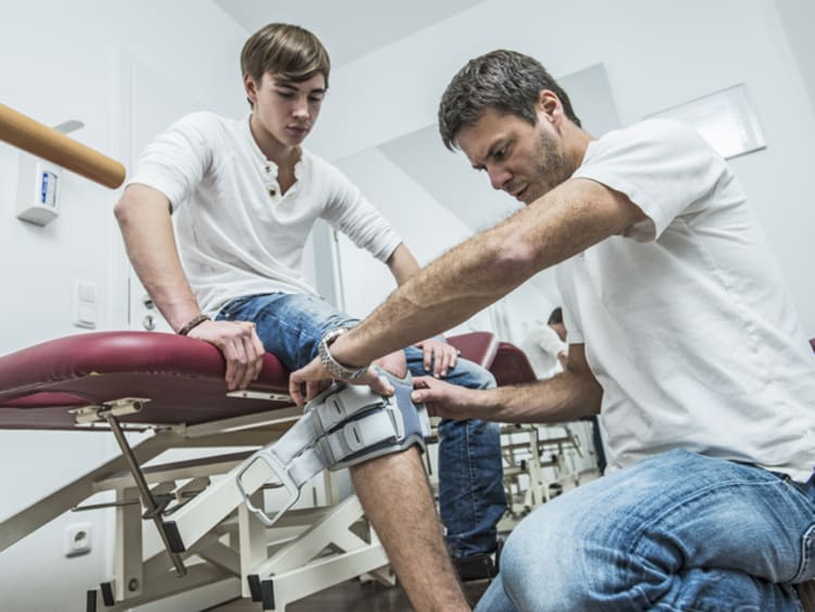 physical therapist looking at a patient's knee